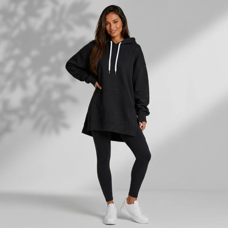 Woman wearing the black Wear the Shape hoodie dress and white trainers