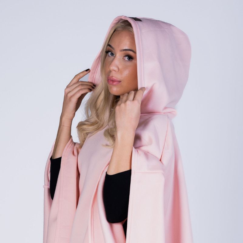 Woman wearing the soft pink Hoodly hoodie blanket with the hood up