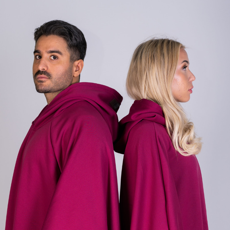 Two people back to back in red Hoodly hoodie blankets