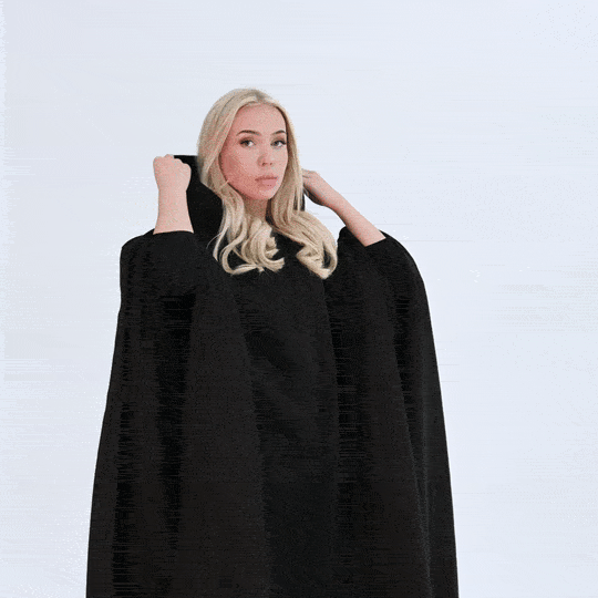 Woman adjusting the hood on a black Hoodly hoodie blanket